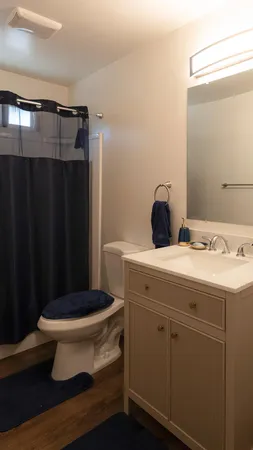 a bathroom with a granite countertop toilet and a sink