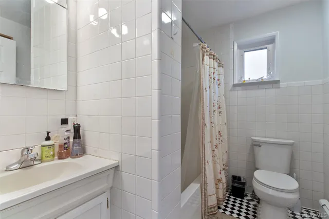 a bed with a painting on the wall and a shower