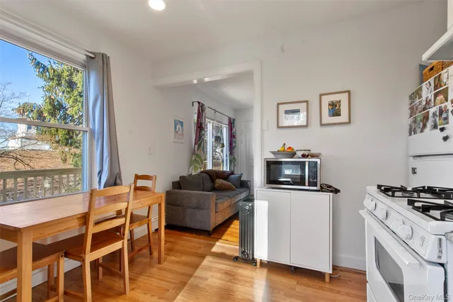 a kitchen with a stove a sink white cabinets and glass table with chairs