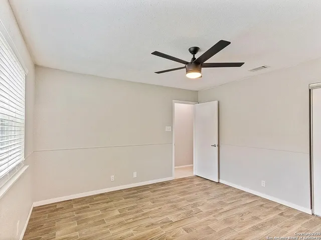 a view of a room with a ceiling fan and window