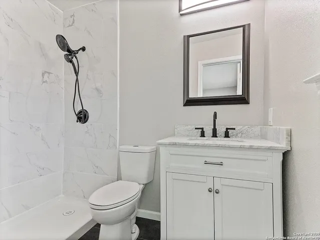 a bathroom with a sink toilet and shower