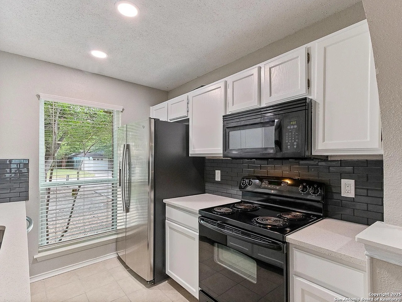 717 Meadow Gate Converse, TX 78109 - Photo 26 of 34 a kitchen with stainless steel appliances a stove a microwave and a sink