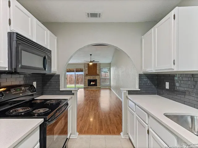 a kitchen with kitchen island a stove a microwave and wooden cabinets