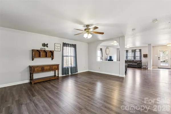 a view of a livingroom with furniture wooden floor a ceiling fan and window