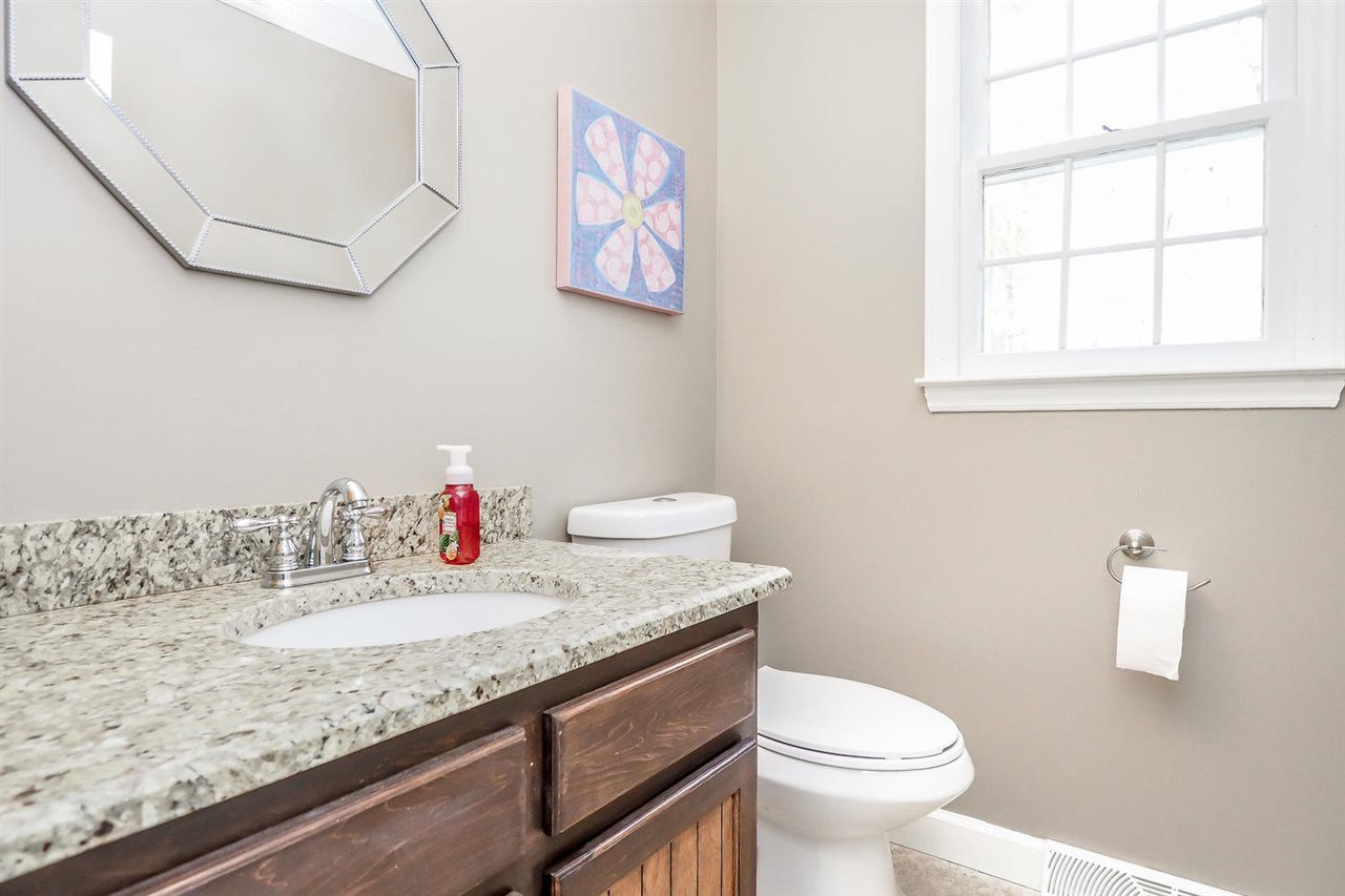 7401 Rolling Dale Court Raleigh, NC 27615 - Photo 12 of 25 All of the bathrooms are updated with fresh paint, new light fixtures, granite counters, comfort height toilets and travertine tile floors. First Floor Half Bathroom