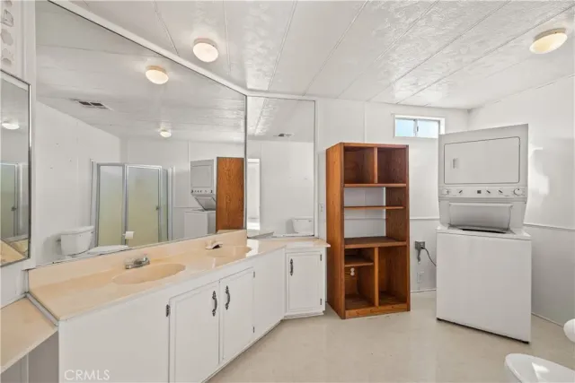 a large white bathroom with a double vanity sink and mirror