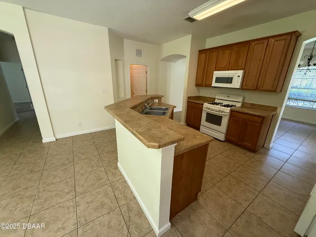 a kitchen with stainless steel appliances granite countertop a stove a sink and a microwave
