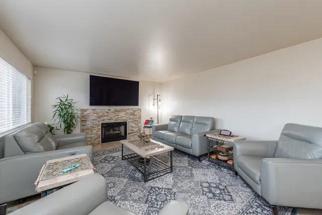a living room with furniture a fireplace and a flat screen tv