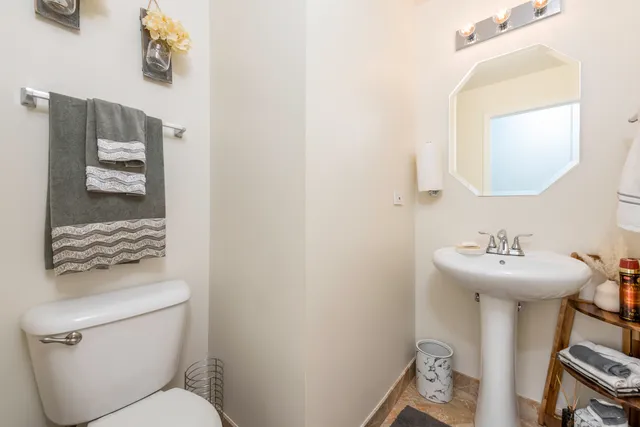 a bathroom with a toilet sink and mirror