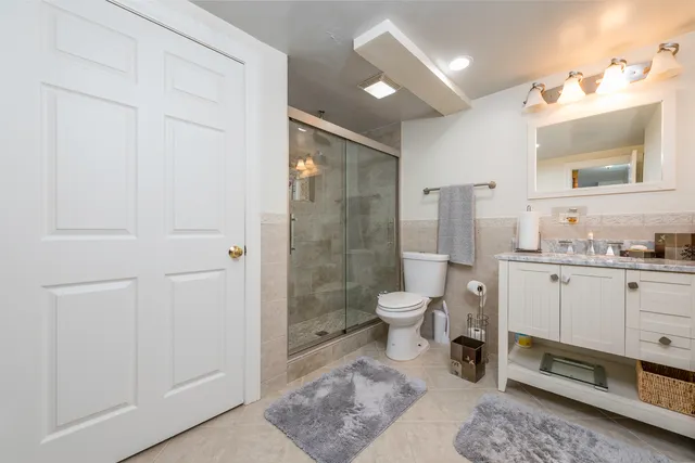 a spacious bathroom with a granite countertop sink mirror and toilet