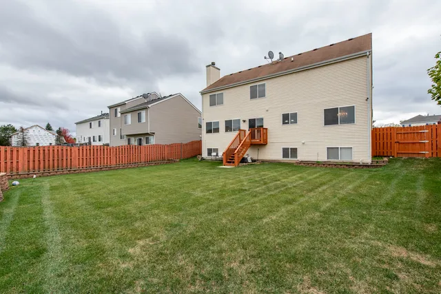 a view of a garden with a bench in front of house