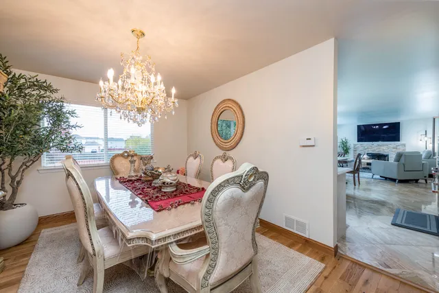 a view of a dining room with furniture a chandelier and wooden floor