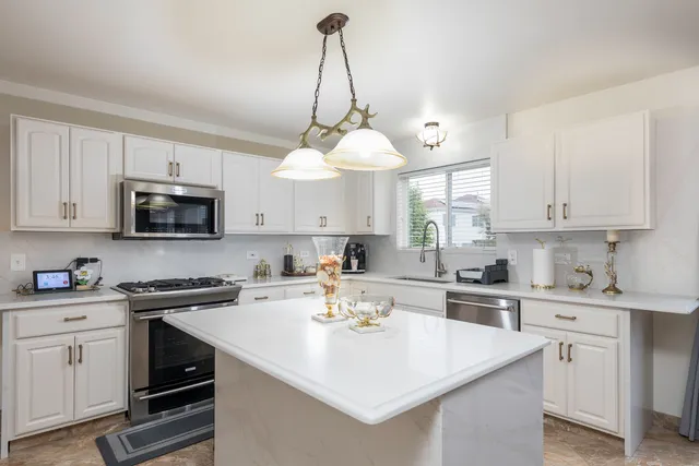 a kitchen with a sink a stove a microwave and cabinets