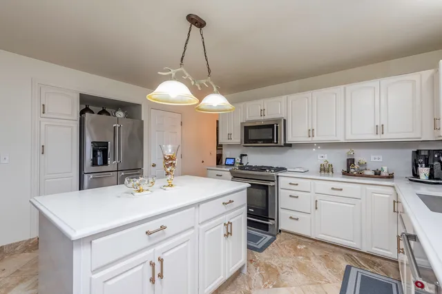 a kitchen that has a sink a stove top oven and white cabinets
