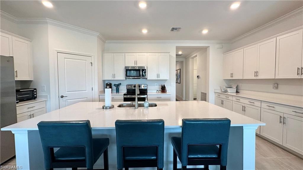 20015 Napa Loop Estero, FL 33928 - Photo 5 of 29 a kitchen with kitchen island a dining table and chairs