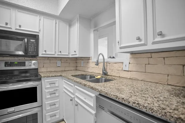 a kitchen with a sink granite counter tops and a sink
