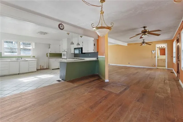a view of a kitchen with a sink oven cabinets and wooden floor
