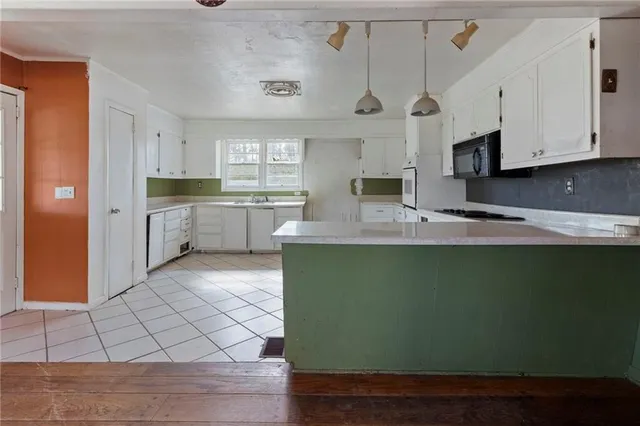 a large kitchen with cabinets and a wooden floor