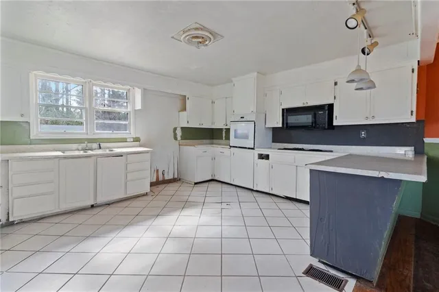 a kitchen with stainless steel appliances a sink window and cabinets