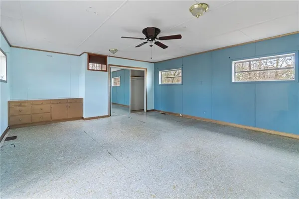 an empty room with ceiling fan and window
