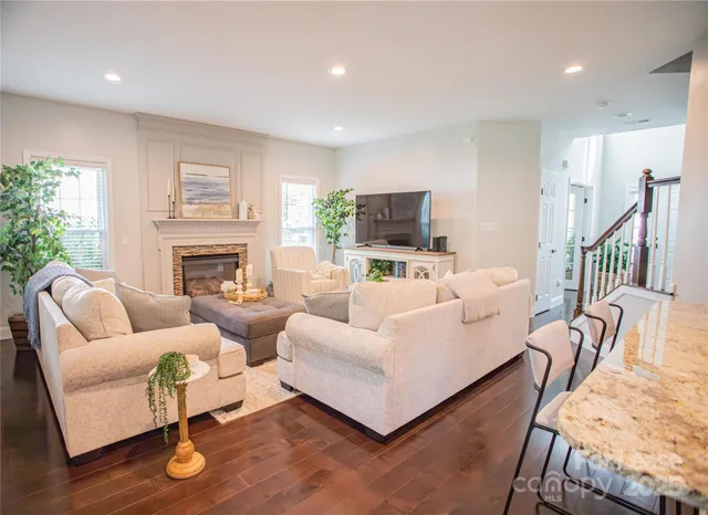 a living room with furniture a fireplace and a flat screen tv