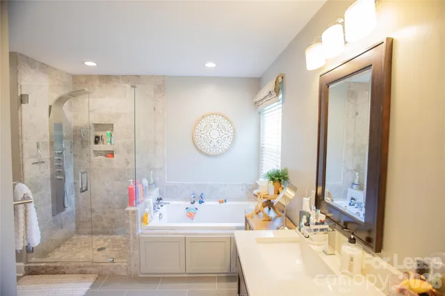 a bathroom with a tub sink and mirror