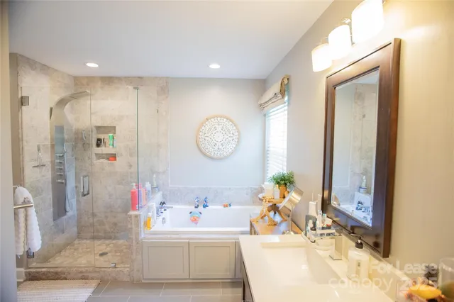 a bathroom with a tub sink and mirror