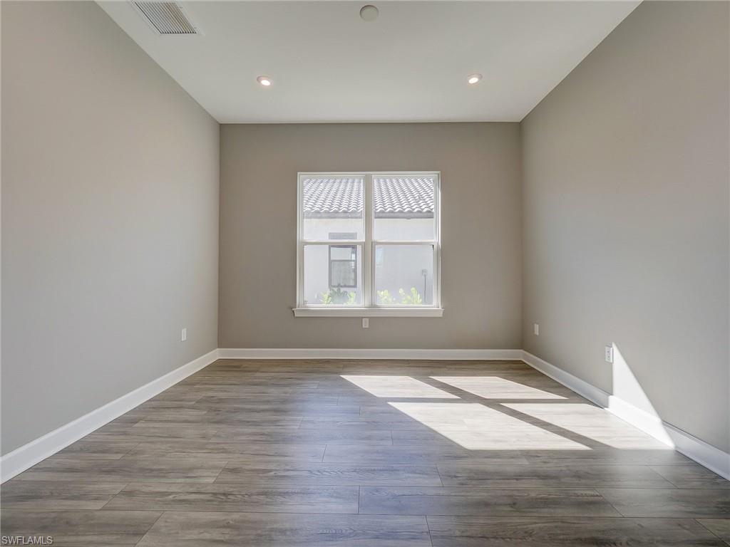 15107 Pescara Street Naples, FL 34114 - Photo 11 of 31 wooden floor in an empty room with a window