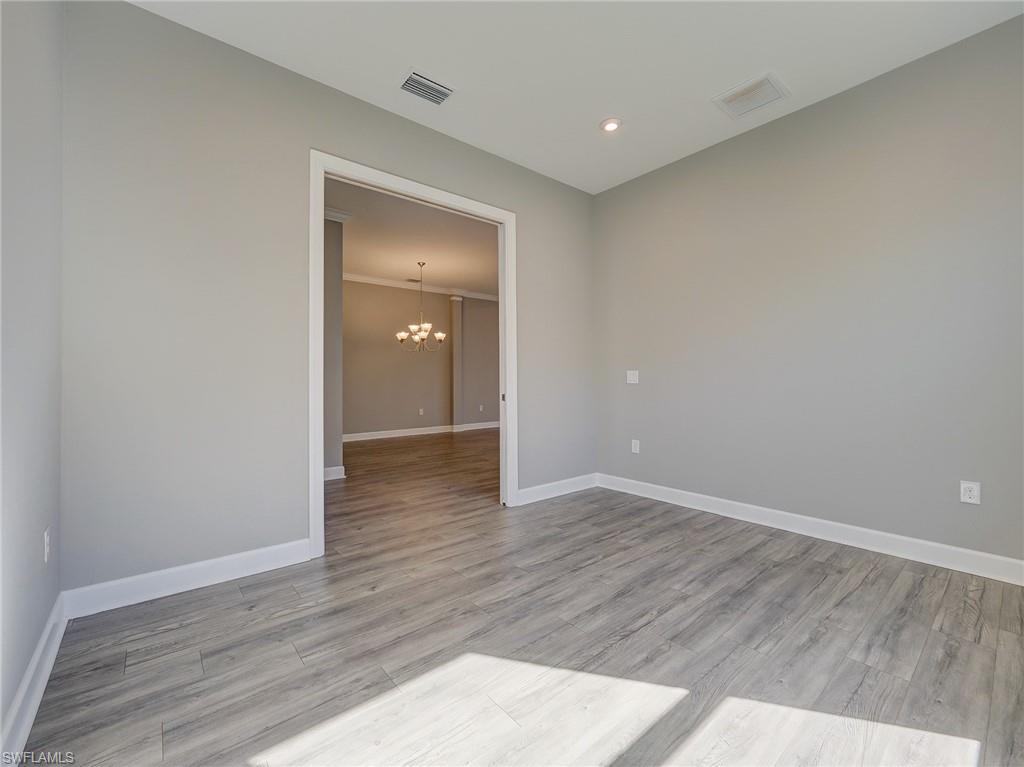 15107 Pescara Street Naples, FL 34114 - Photo 12 of 31 a view of an empty room with wooden floor and closet