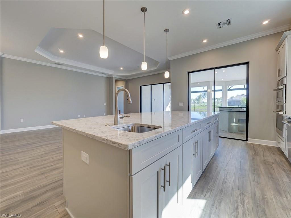 15107 Pescara Street Naples, FL 34114 - Photo 19 of 31 a large kitchen with a sink and wooden floor