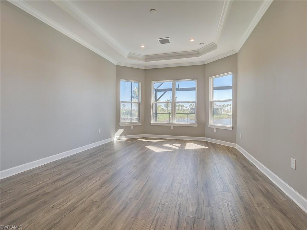 15107 Pescara Street Naples, FL 34114 - Photo 22 of 31 an empty room with wooden floor and windows