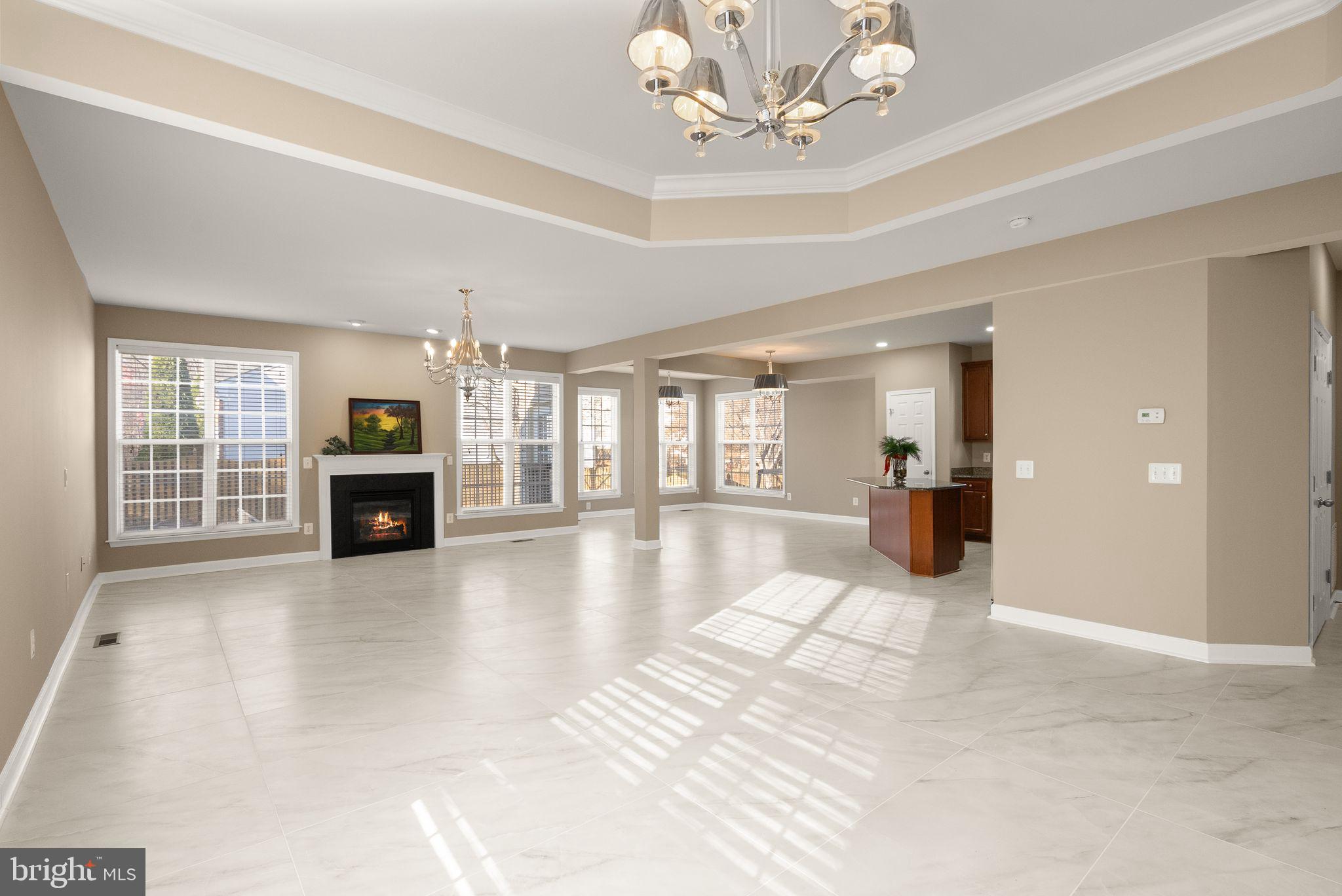 7722 Yalta Way Gainesville, VA 20155 - Photo 17 of 75 a view of an empty room with a fireplace and chandelier