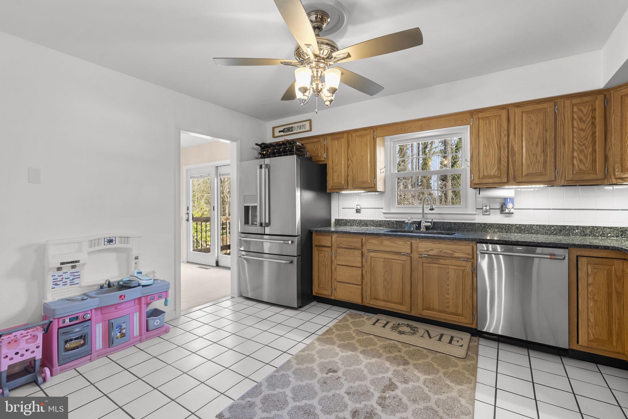 712 Petersburg Road Davidsonville, MD 21035 - Photo 8 of 37 a kitchen with stainless steel appliances granite countertop a sink dishwasher stove and refrigerator with wooden floor