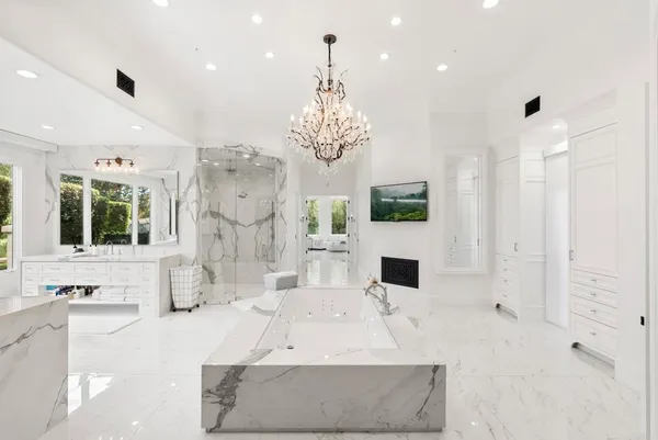 a large living room with fireplace furniture and a chandelier