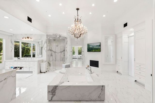 a large living room with fireplace furniture and a chandelier