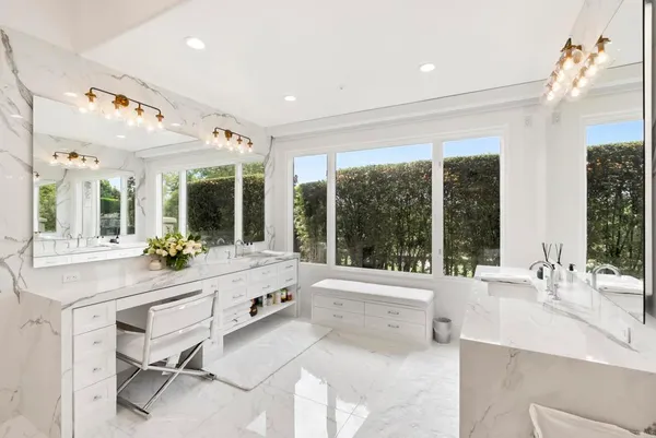 a large white bathroom with a large tub and sink