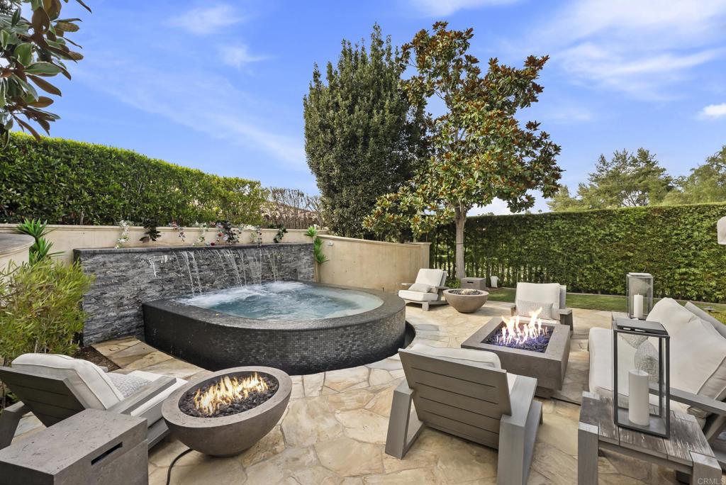 6853 Rancho Valencia Road Rancho Santa Fe, CA 92067 - Photo 18 of 40 a view of a patio with table and chairs potted plants and a palm tree