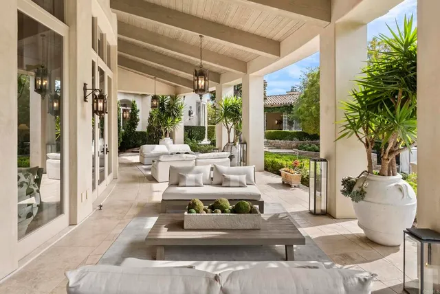 a living room with patio furniture and potted plants