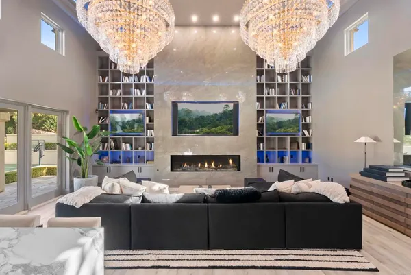 a living room with large windows and a chandelier