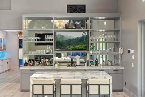 a kitchen with a stove a sink and a dining table with wooden floor