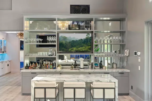 a kitchen with a stove a sink and a dining table with wooden floor