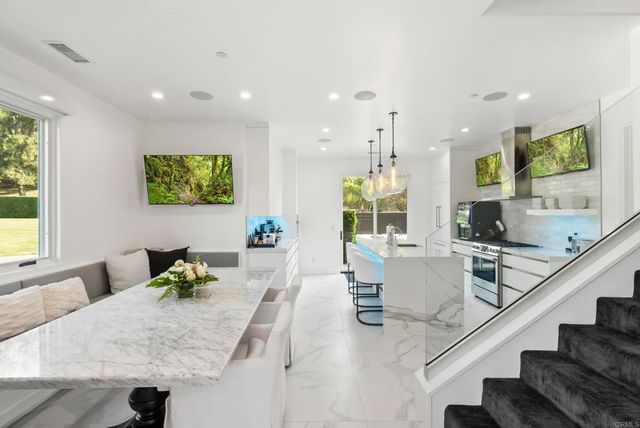 a living room with furniture kitchen view and a large window