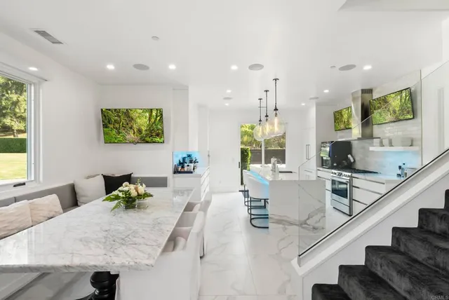 a living room with furniture kitchen view and a large window