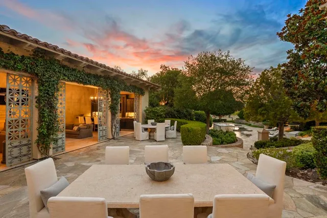 a view of swimming pool with lawn chairs and plants