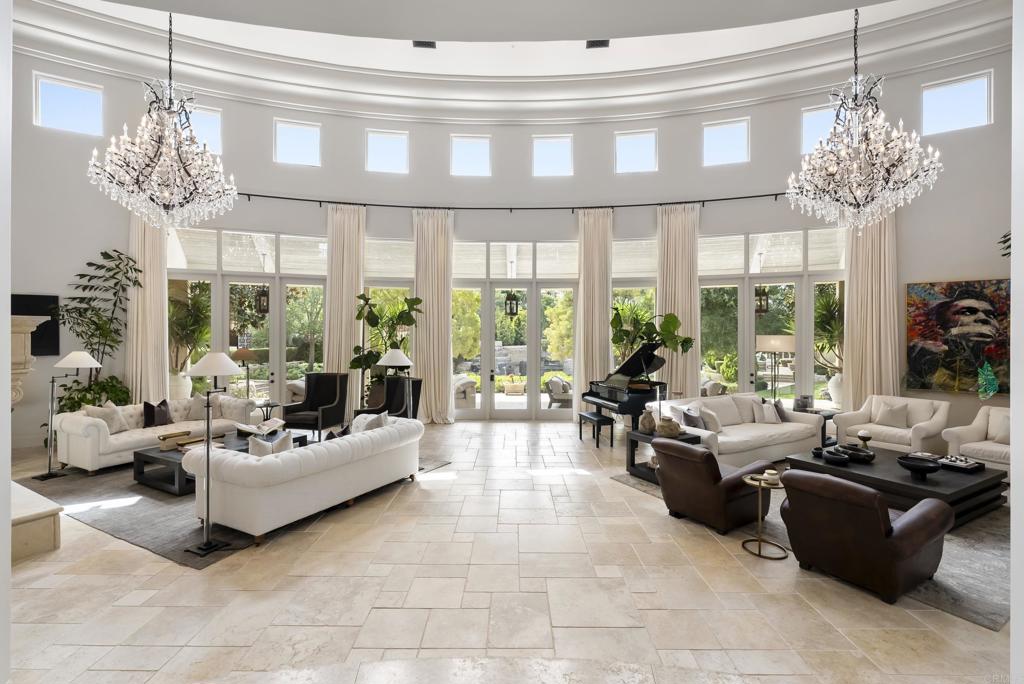 6853 Rancho Valencia Road Rancho Santa Fe, CA 92067 - Photo 5 of 40 a living room with furniture a chandelier and a large window