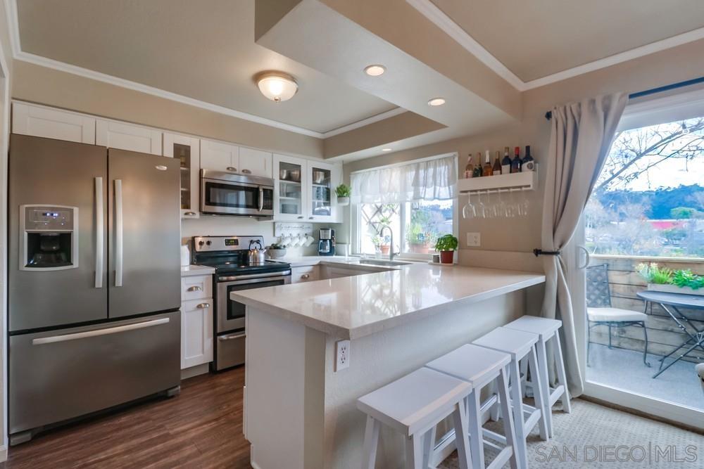 a large kitchen with stainless steel appliances granite countertop a sink a stove and a refrigerator