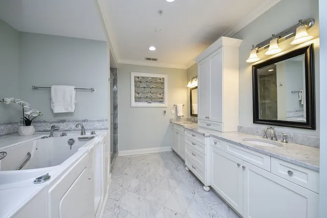 a bathroom with a double vanity sink mirror and bathtub