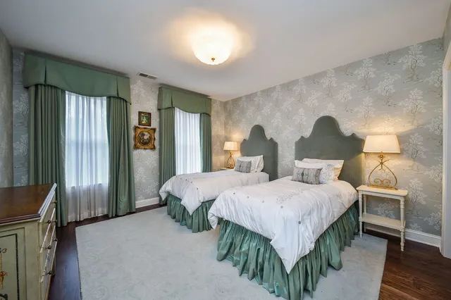 a spacious bedroom with two beds and a chandelier