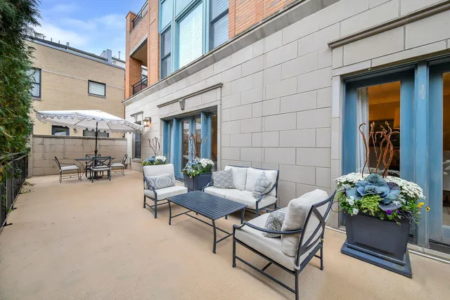 a view of a patio with couches and a potted plant on a street
