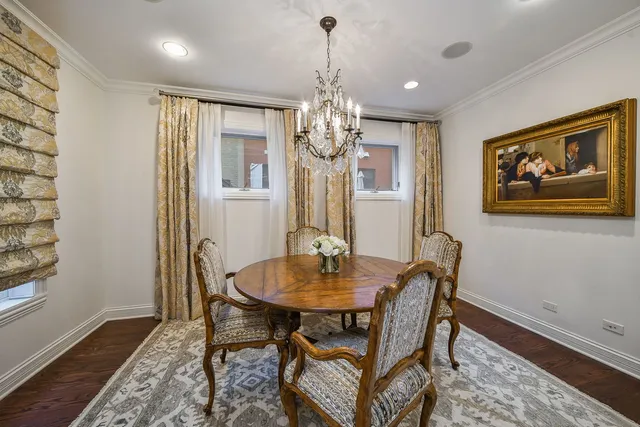 a dining room with furniture a chandelier and wooden floor